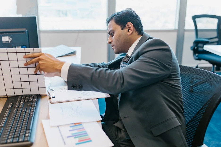 A professional analyst reviewing financial charts on a modern computer screen.